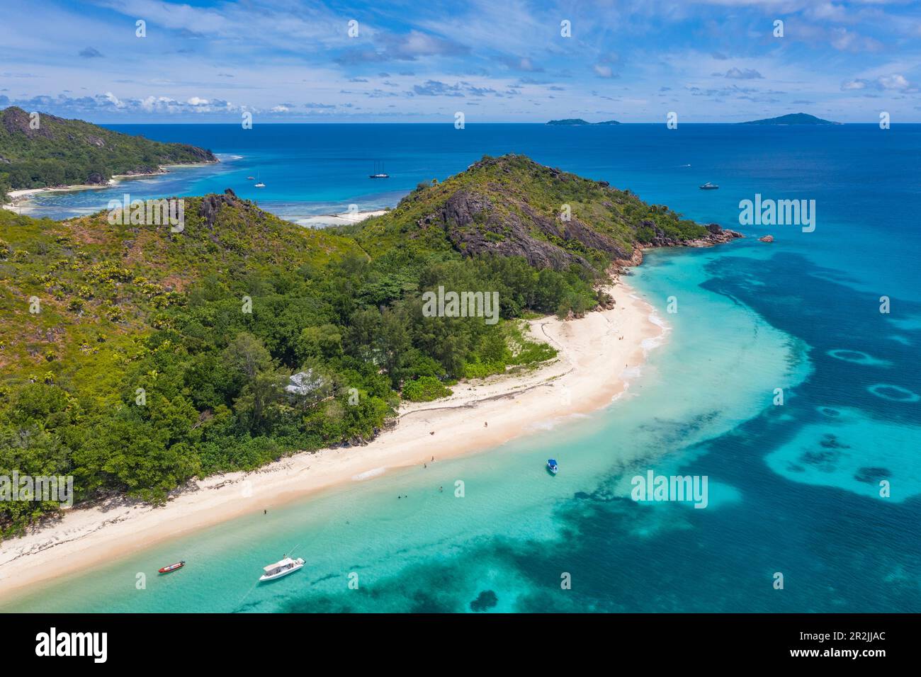 Veduta aerea di Anse St. Spiaggia Jose con barche a vela nella baia di Baie Laraie in lontananza, isola di Curieuse, Seychelles, Oceano Indiano Foto Stock
