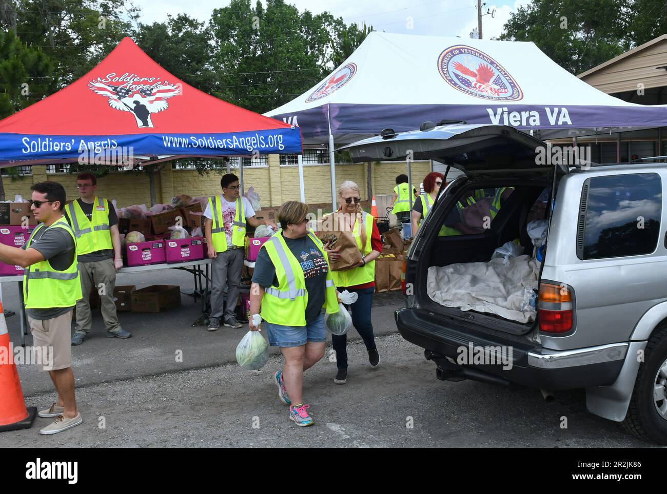 Orlando, Stati Uniti. 19th maggio, 2023. I volontari collocano gli articoli alimentari in veicoli in occasione di un evento di distribuzione alimentare militare e veterano per coloro che ne hanno bisogno, sponsorizzato da Lockheed Martin e dagli angeli nazionali no profit Soldiersí presso la clinica del Lago Baldwin VA di Orlando. In riconoscimento del mese dell'apprezzamento militare, 200 veterani preregistrati dell'area di Orlando, militari attivi, guardiani e riservisti hanno ricevuto in media 75 libbre di frutta e verdura fresca, carni e non-deperibili all'evento. (Foto di Paul Hennessy/SOPA Images/Sipa USA) Credit: Sipa USA/Alamy Live News Foto Stock