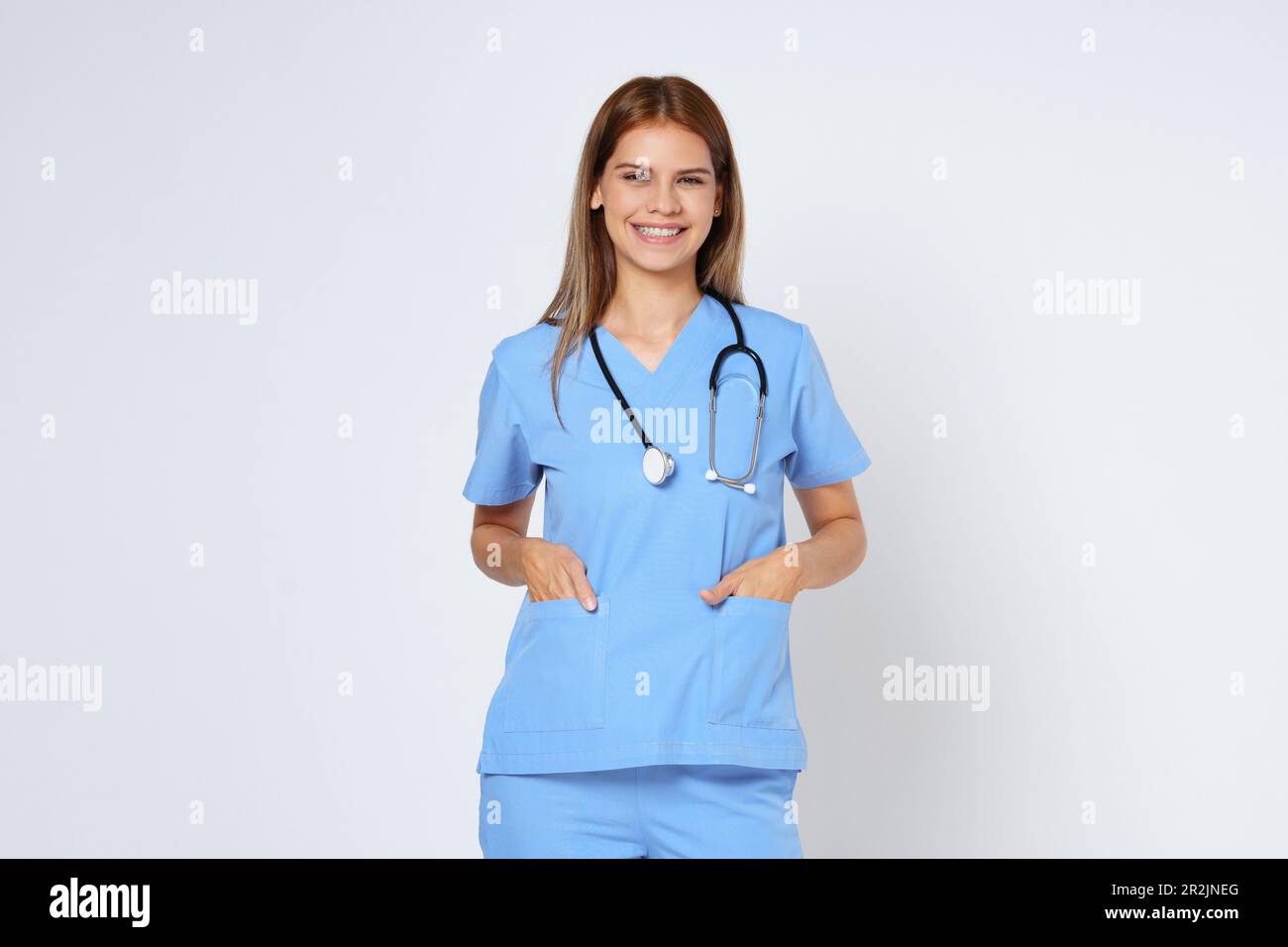 Giovane donna sorridente dottore con stetoscopio su sfondo bianco. Foto Stock