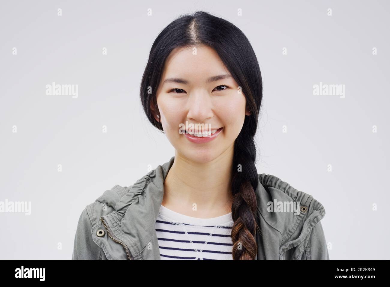 Ritratto, felice o sorriso con una donna asiatica in studio su sfondo bianco per la moda giapponese. Faccia, contemporaneo o stile con un giovane attraente Foto Stock