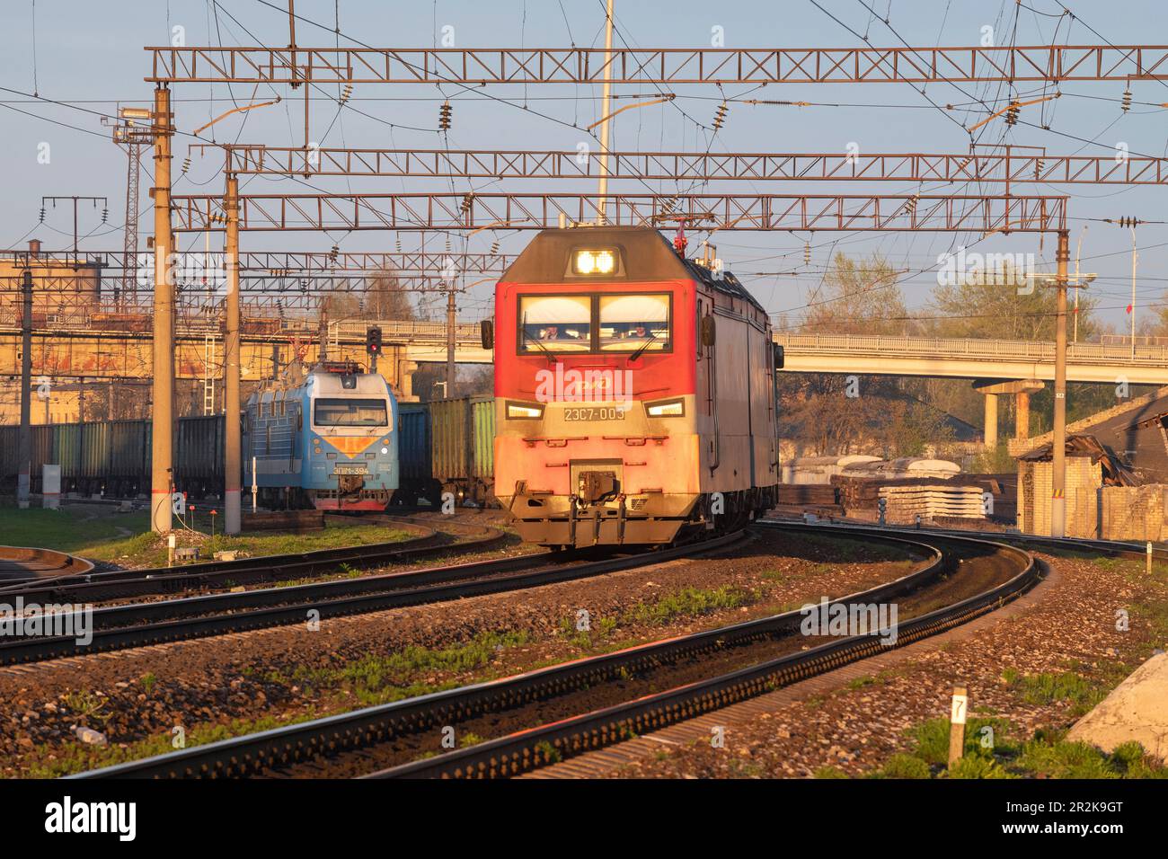 SHARYA, RUSSIA - 02 MAGGIO 2023: La moderna locomotiva elettrica russa 2ES7 "Granite Nera" con un treno merci parte dalla stazione in un sole maggio anche Foto Stock