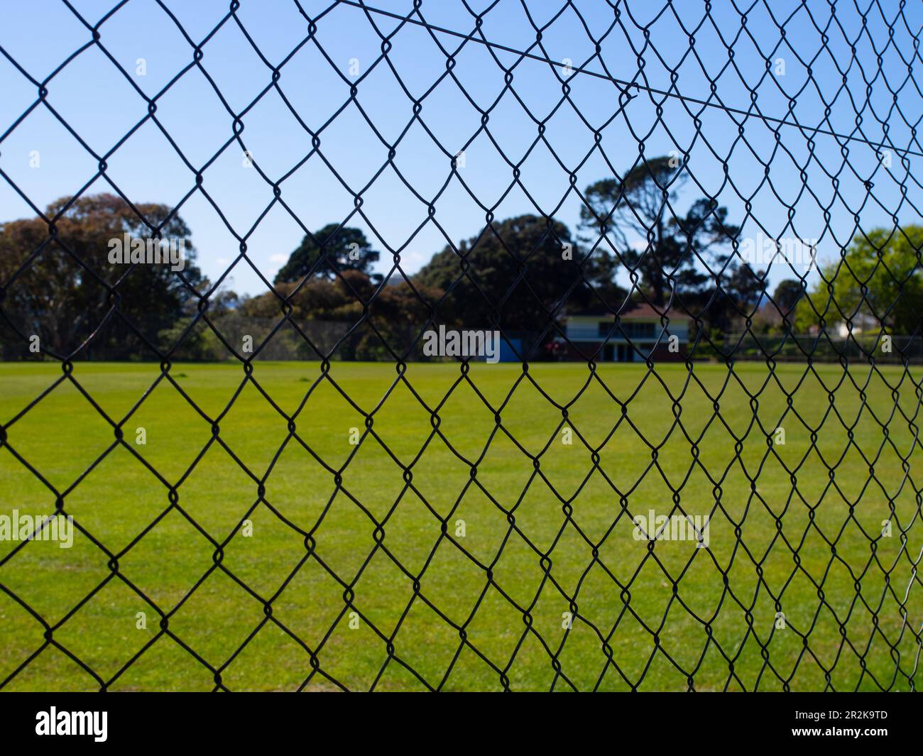 Campo sportivo paesaggistico attraverso Una recinzione a filo Foto Stock