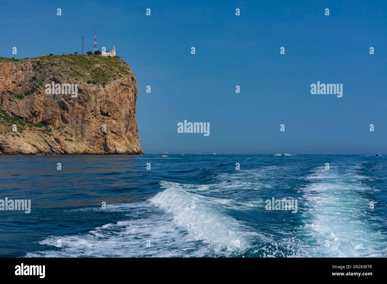 Faro di Cabo de San Antonio, a Jávea, nel parco naturale del Montgo. Piccolo faro in cima alla scogliera. Dal mare a bordo di una barca Foto Stock