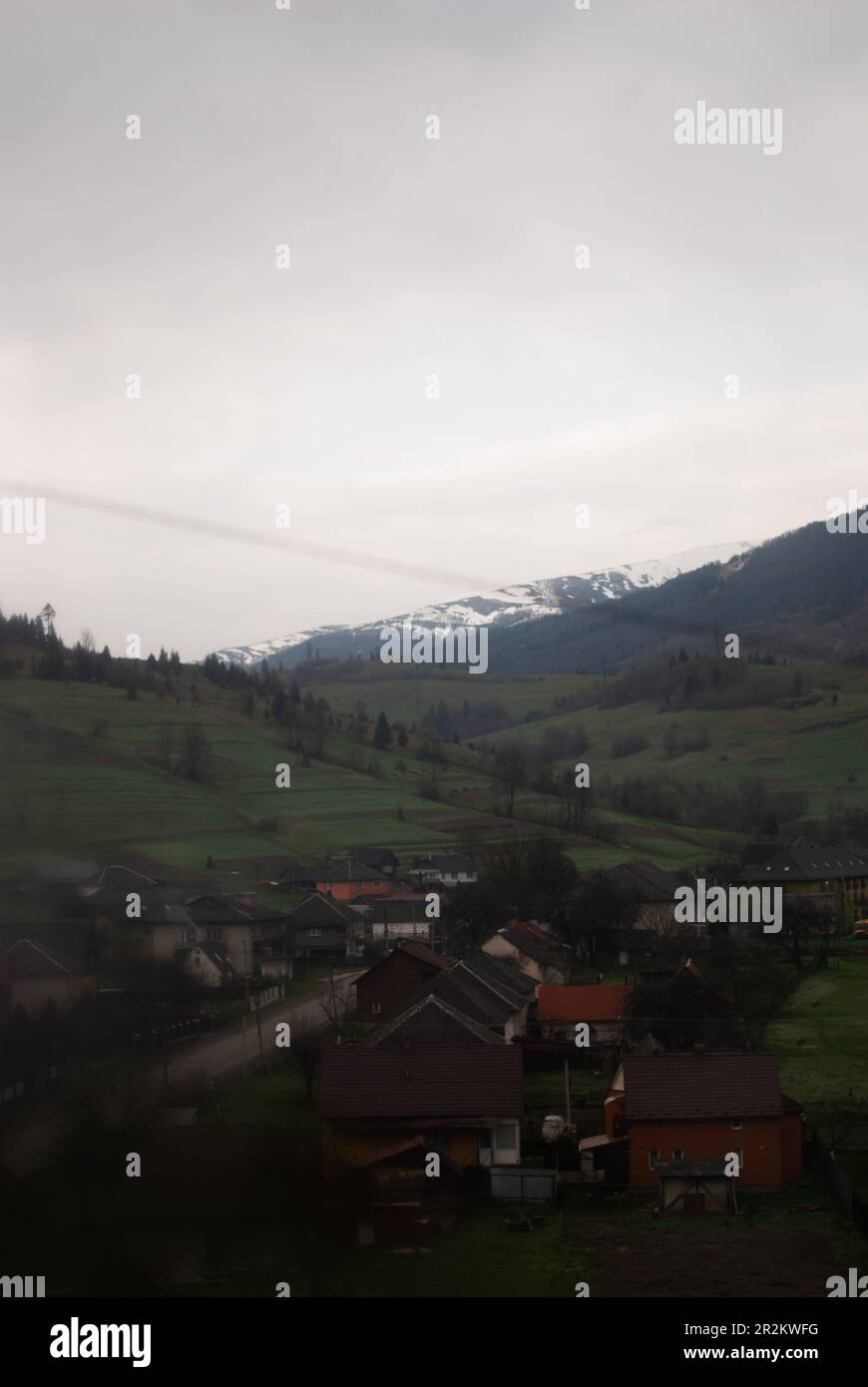 Verdi colline e montagne attraverso la finestra del treno Foto Stock