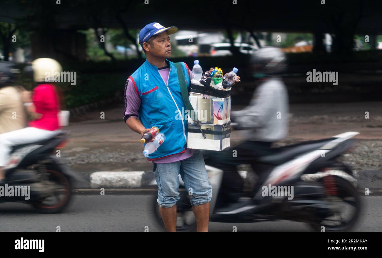 Uomo indonesiano che vende bevande sulla strada a Giacarta Foto Stock
