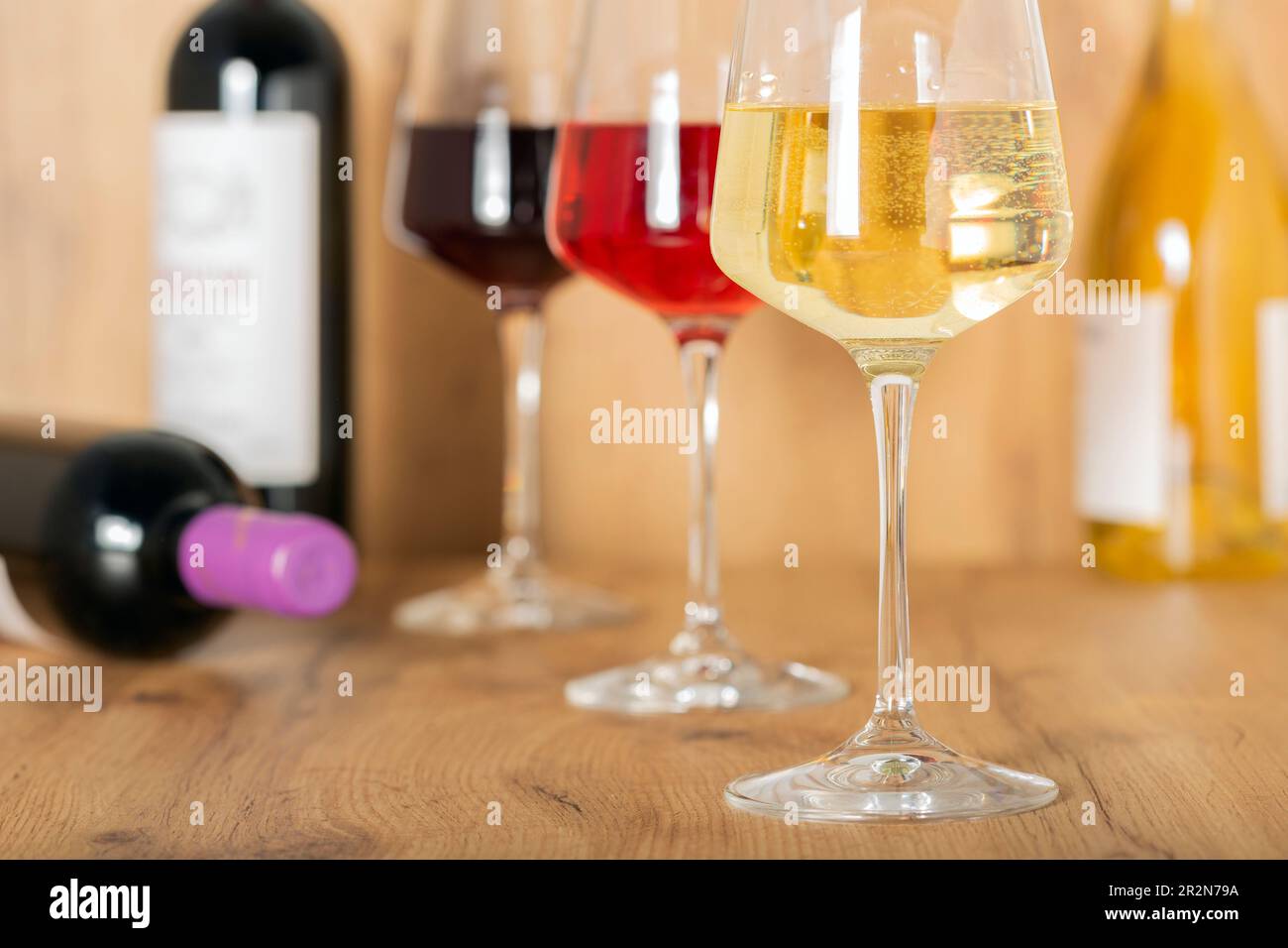 Esperienza di degustazione nella cantina rustica e nel wine bar: Bicchiere di vino rosso, bianco e rosato e collezione di vini pregiati sullo sfondo Foto Stock