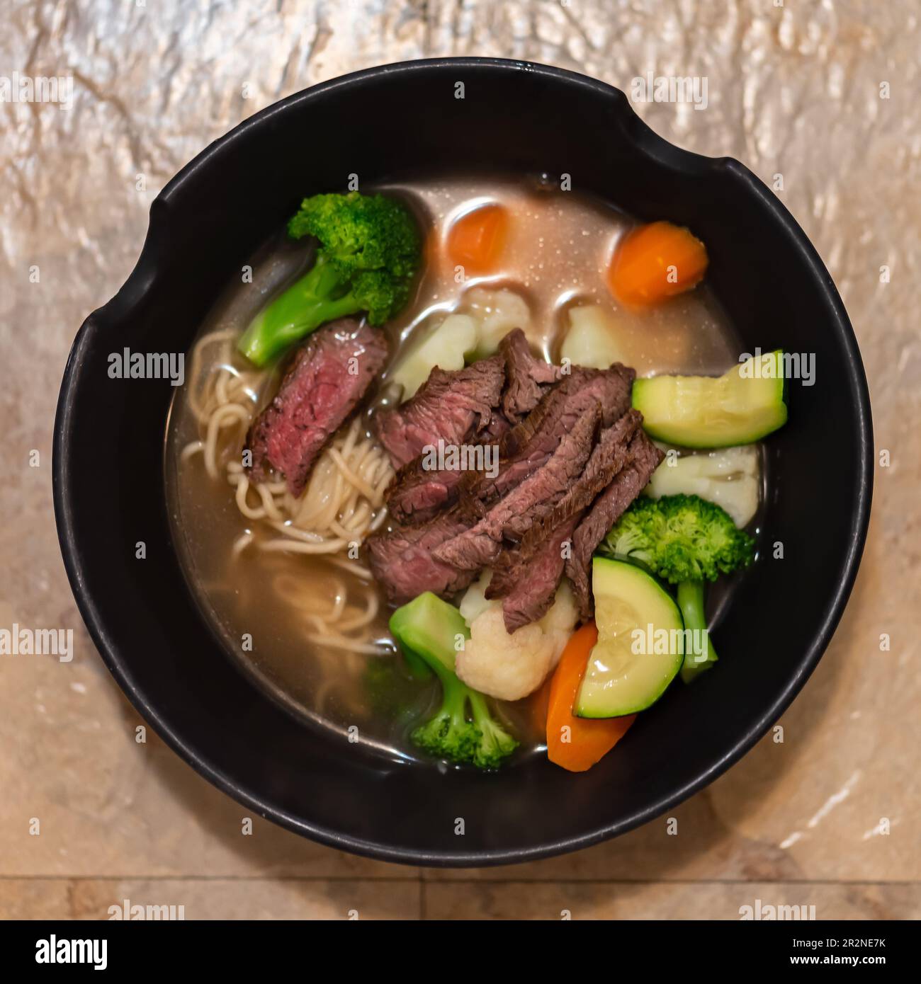 Bistecca di manzo alla griglia e minestra di verdure estive in stile asiatico di Ramen noodle. Foto Stock