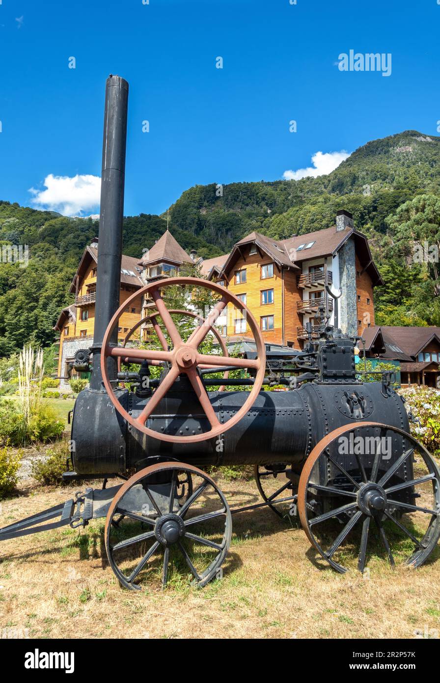 Vecchio modello di locomotiva a vapore d'epoca con Hotel natura sullo sfondo, Ande Montagne, Puerto Peulla Cile Foto Stock