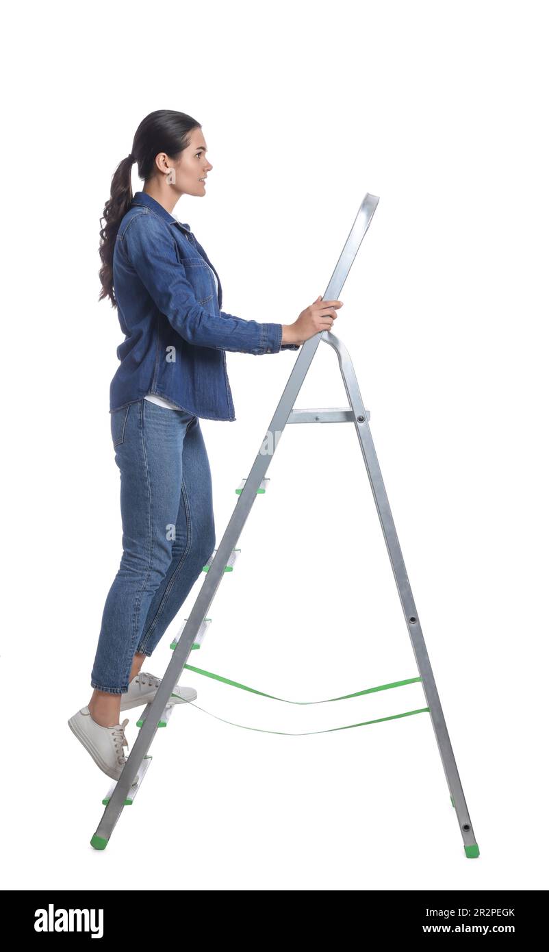 Giovane donna che sale su scala di metallo su sfondo bianco Foto Stock