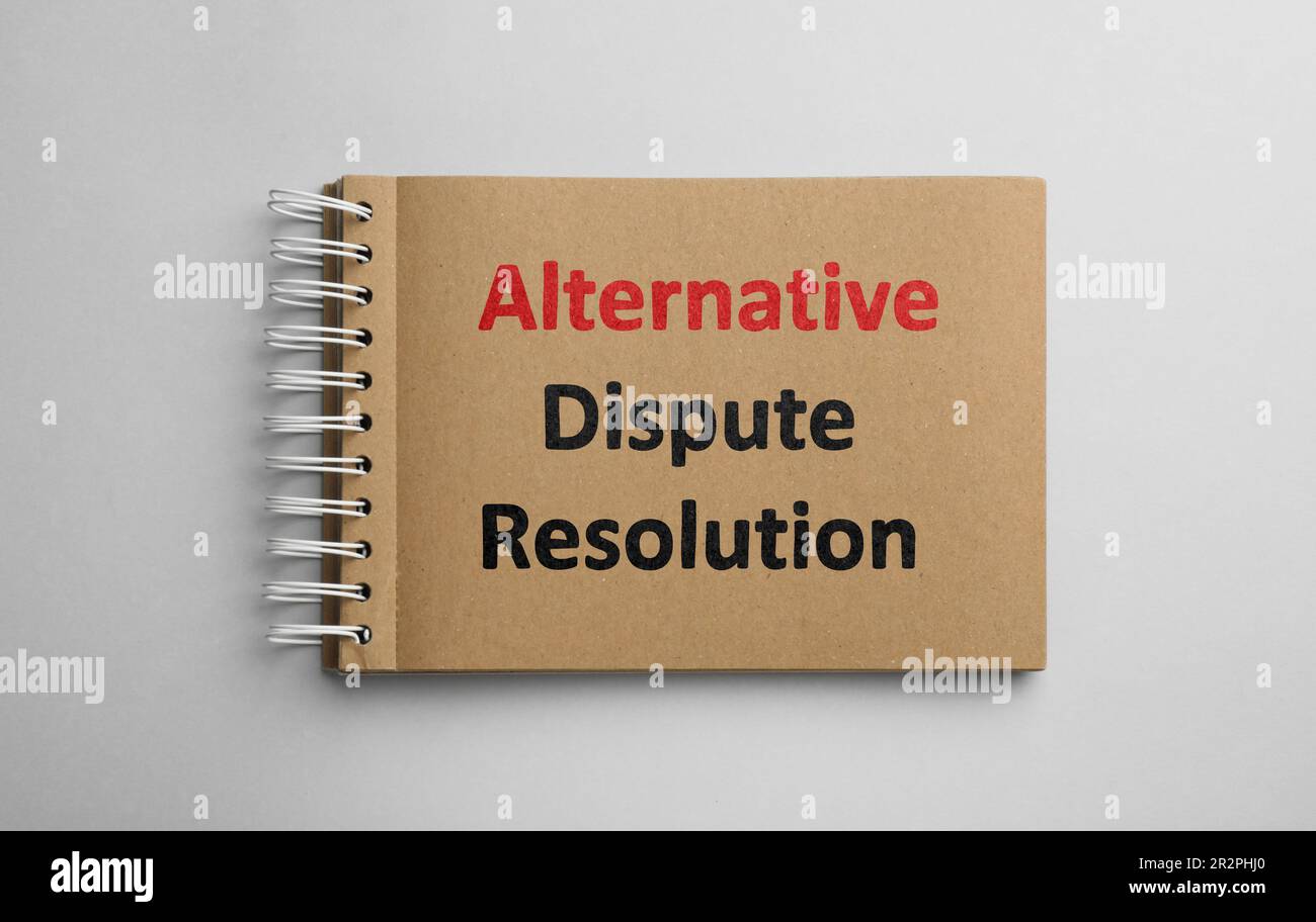 Notebook con frase risoluzione alternativa delle controversie su sfondo bianco, vista dall'alto Foto Stock