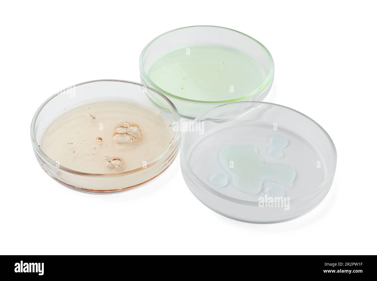 Capsule di Petri con liquidi diversi su fondo bianco Foto Stock