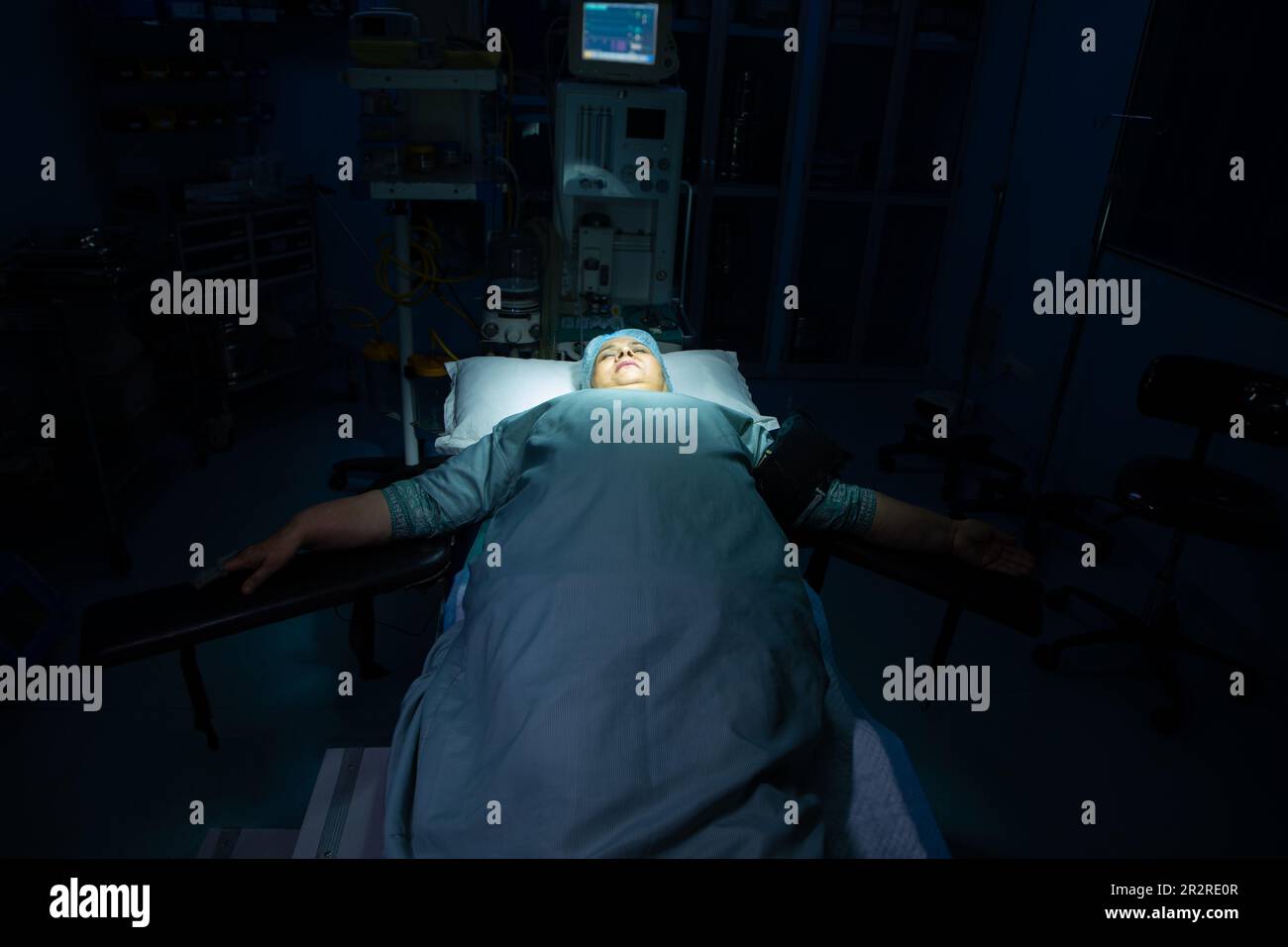 Paziente indiano anziano sdraiato sul letto nella sala operatoria dell'ospedale. Foto Stock
