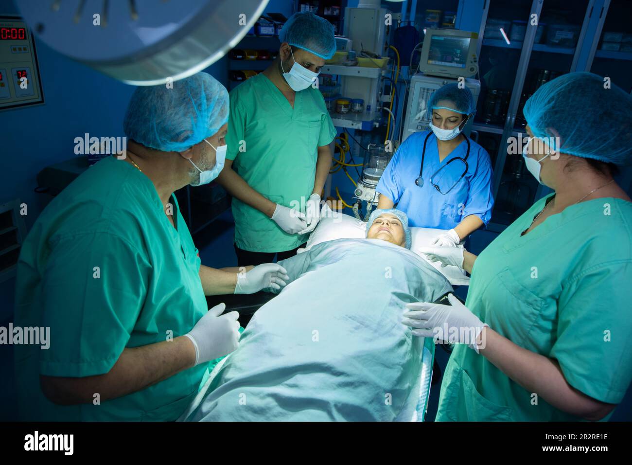 il team medico dei chirurghi ndiani che esegue la chirurgia in teatro operatorio in ospedale. Concetto di assistenza medica. Foto Stock