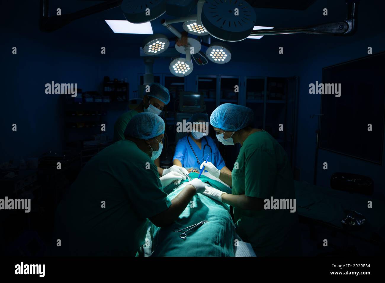 il team medico dei chirurghi ndiani che esegue la chirurgia in teatro operatorio in ospedale. Concetto di assistenza medica. Foto Stock