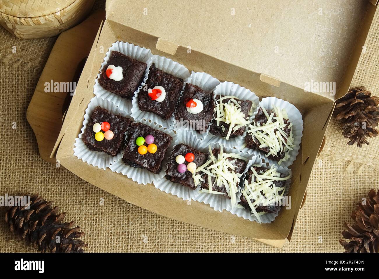 Brownie al cioccolato in una scatola con vari condimenti Foto Stock