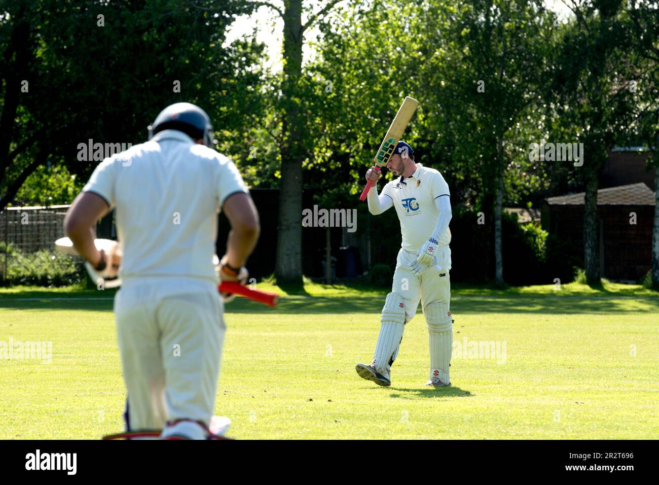 Club cricket, Warwick, Inghilterra, Regno Unito. Battitore che esce dal campo, il prossimo battitore che continua. Foto Stock