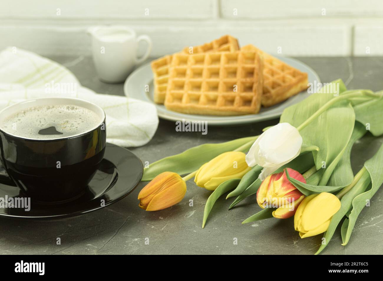 Waffle belgi per colazione, fiori freschi e caffè. Fragole fresche e waffle. Spazio di copia Foto Stock