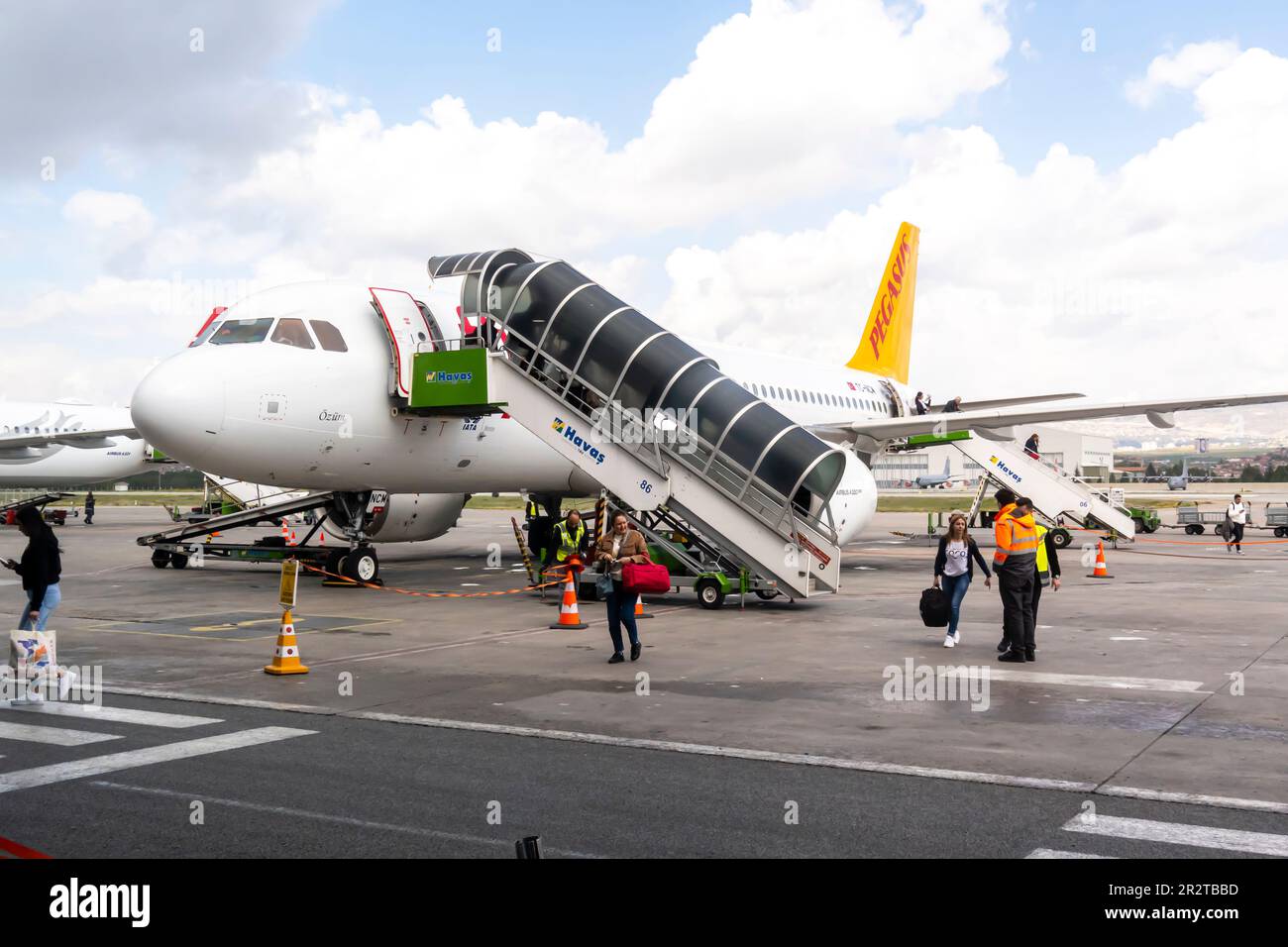 I passeggeri che lasciano Pegasus aereo compagnie aeree su asfalto, i turisti a piedi per l'aeroporto su asfalto. Sabiha Gokcen aeroporto Istanbul Turchia Foto Stock