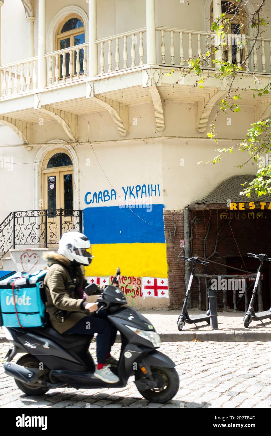 Slava Ucraina graffiti, Ucraina bandiera murale su un edificio nella città vecchia Tbilisi Georgia. Gloria al murale Ucraina, bandiera Ucraina. Foto Stock