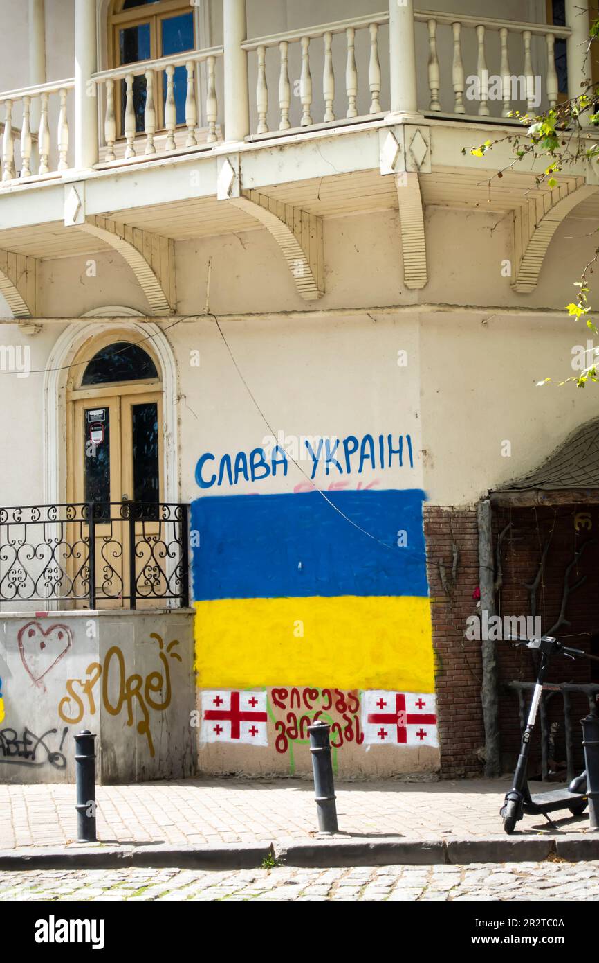 Slava Ucraina graffiti, Ucraina bandiera murale su un edificio nella città vecchia Tbilisi Georgia. Gloria al murale Ucraina, bandiera Ucraina. Foto Stock