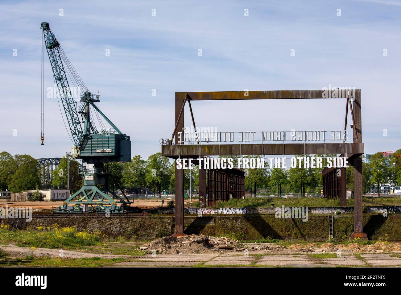 Gru e l'installazione d'arte Vedi le cose dall'altra parte di Tim Etchells su un vecchio ponte di carico nel porto del Reno Deutz, Colonia, Germania. KR Foto Stock