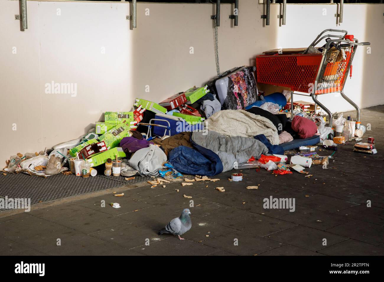 Senzatetto con i suoi possedimenti e un sacco di spazzatura si trova in via Caecilien nel centro della città, sotto una zona coperta del marciapiede, Colonia, GE Foto Stock