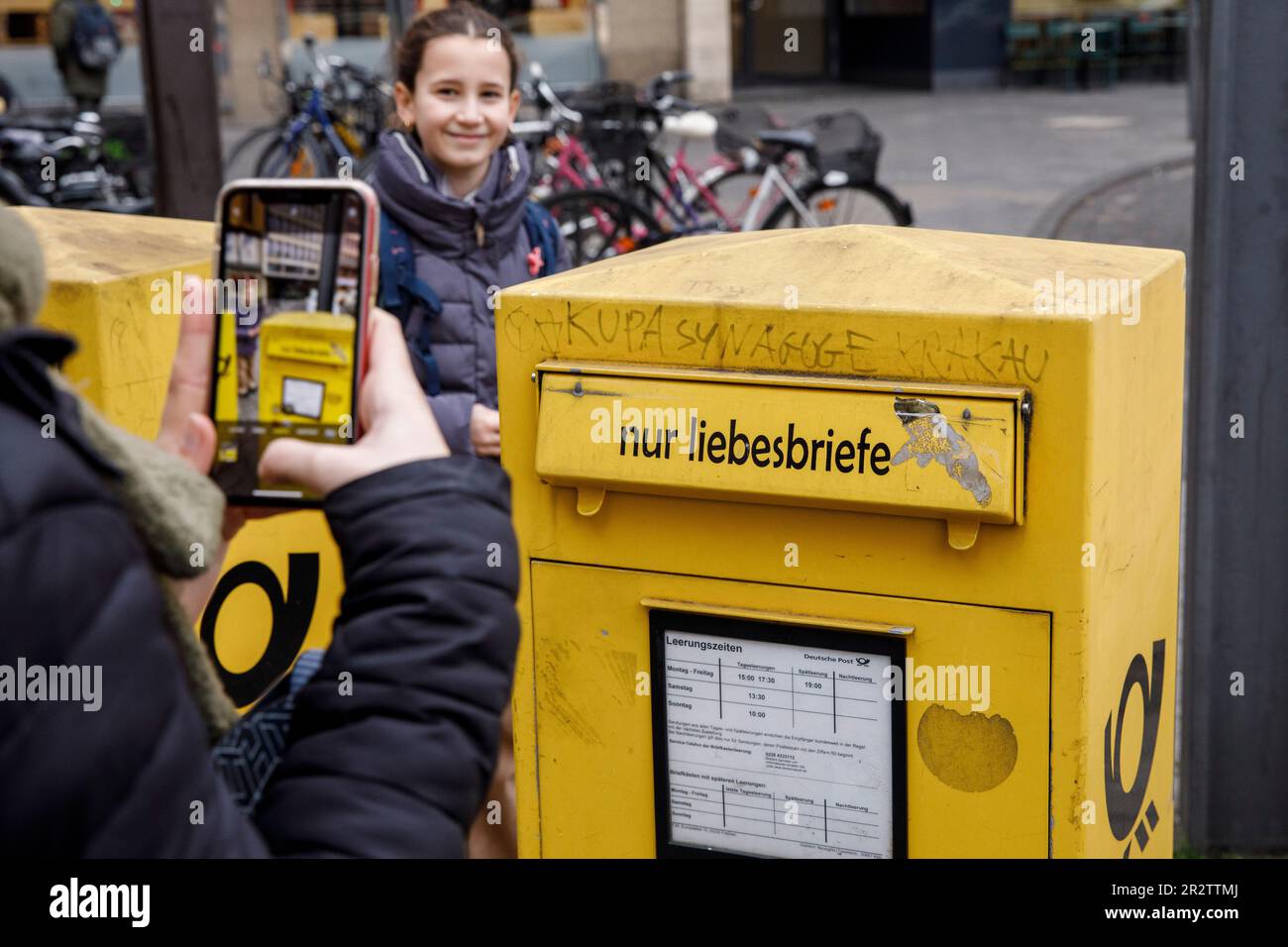Donna scatta foto con il suo cellulare di una casella di posta solo per lettere d'amore in città, Colonia, Germania. Frau fotografiert mit einem Handy einen Foto Stock