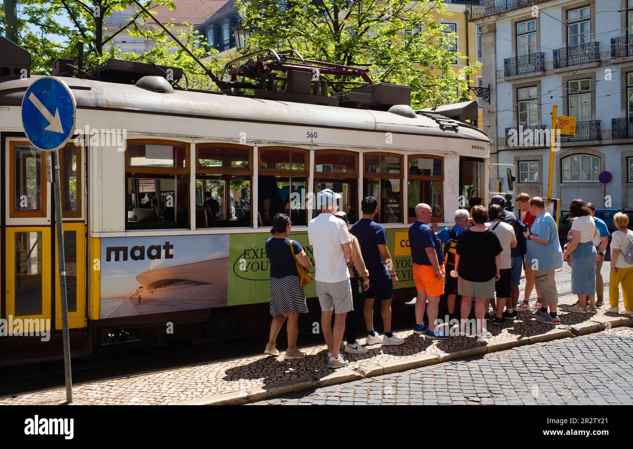 Folla di turisti su uno dei famosi tram gialli di Lisbona Foto Stock