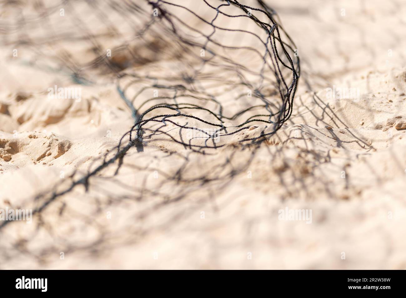 Pallavolo in rete ombre sulla sabbia per il design dello sfondo. Concetto di squadra sportiva. Poster con tema sportivo orizzontale, biglietti d'auguri, intestazioni, sito Web e app Foto Stock