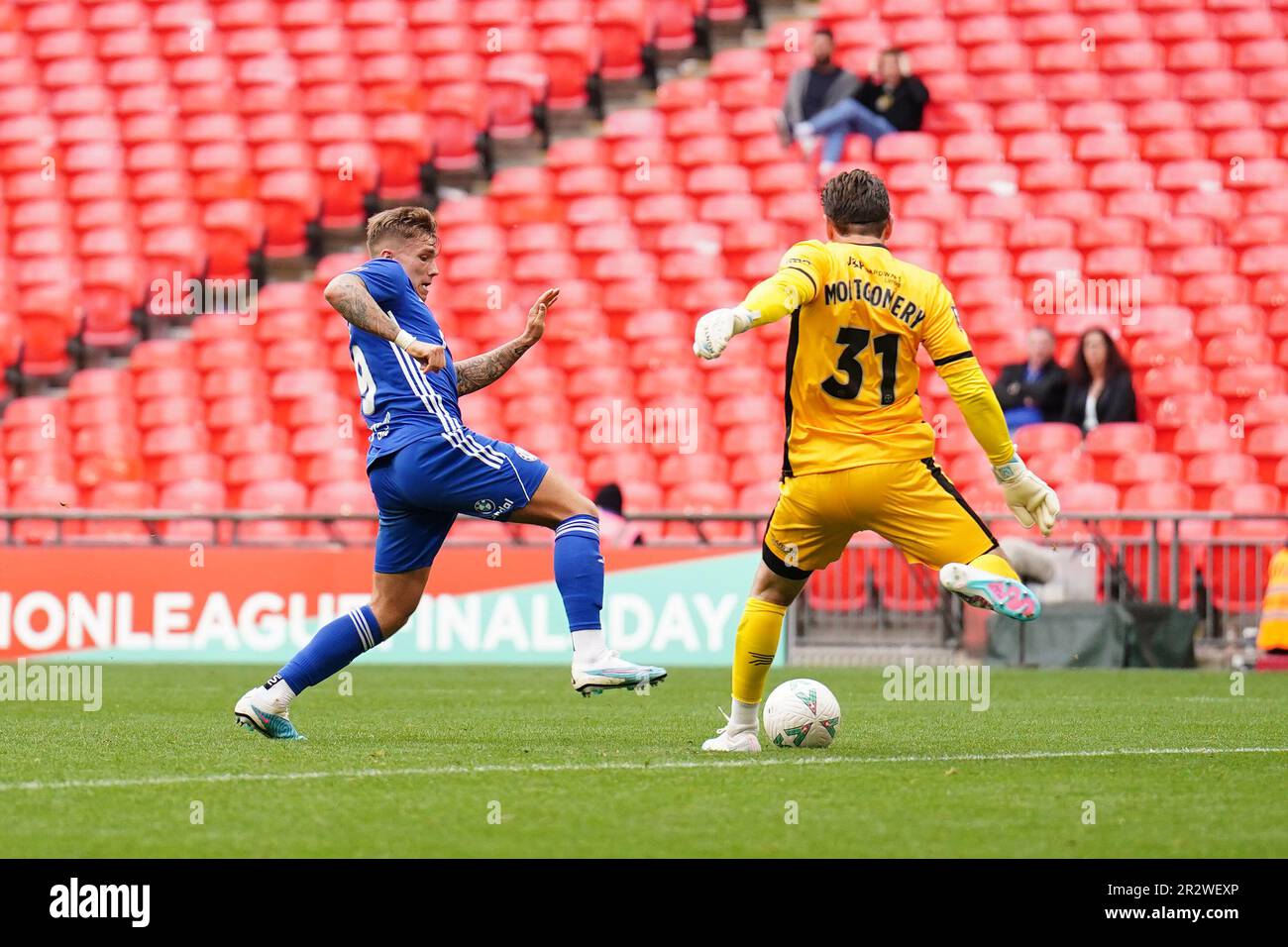 James Montgomery di Gateshead (a destra) calcia la palla contro Jamie Cooke del FC Halifax Town, che si traduce nel primo goal del FC Halifax Town durante la finale del trofeo Isuzu fa allo stadio di Wembley, Londra. Data immagine: Domenica 21 maggio 2023. Foto Stock