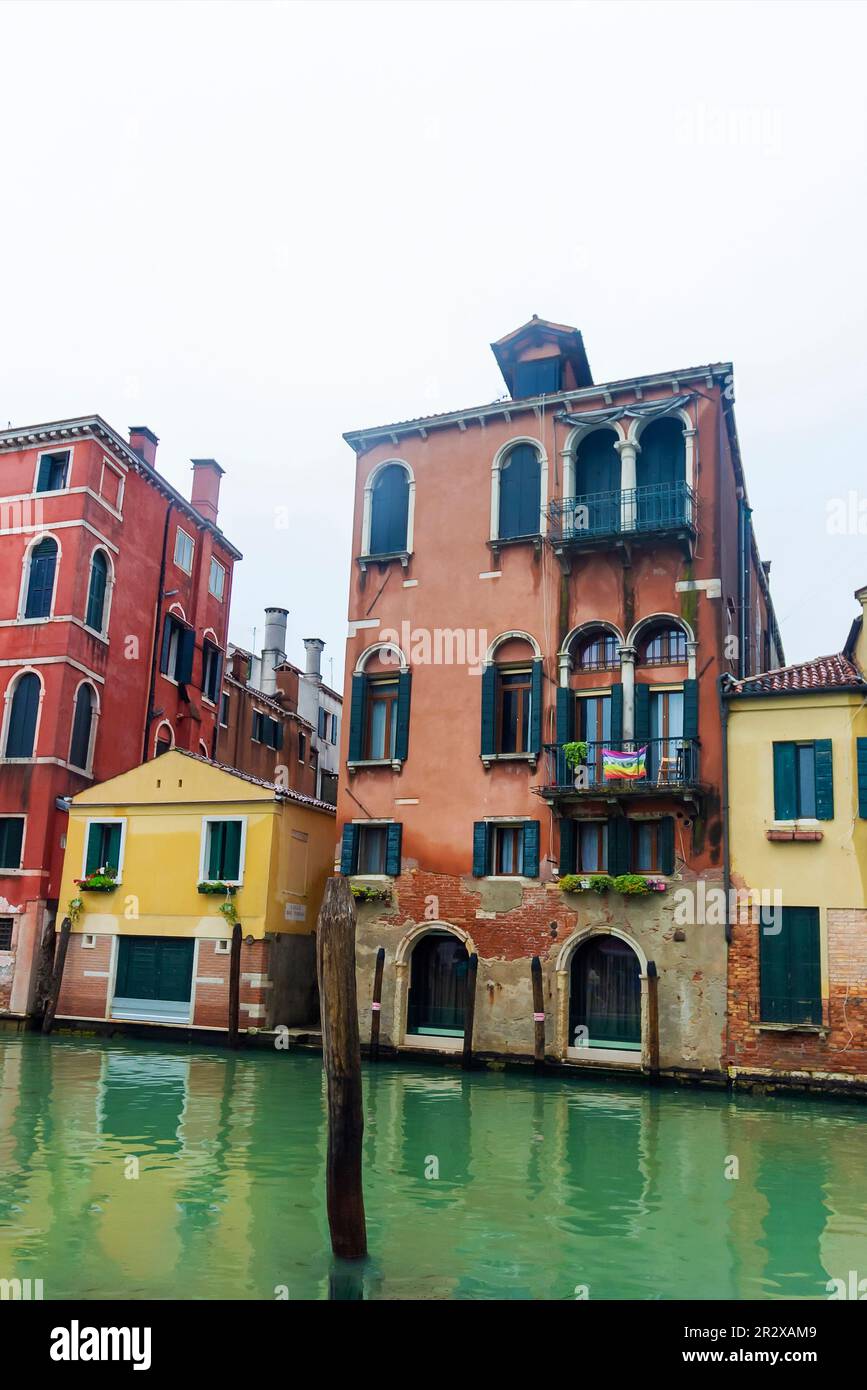 Una vista tipica del centro storico di Venezia, Italia, con antichi edifici immersi nell'acqua. Sul balcone è presente una bandiera LGBT. Maggio 2023 Foto Stock