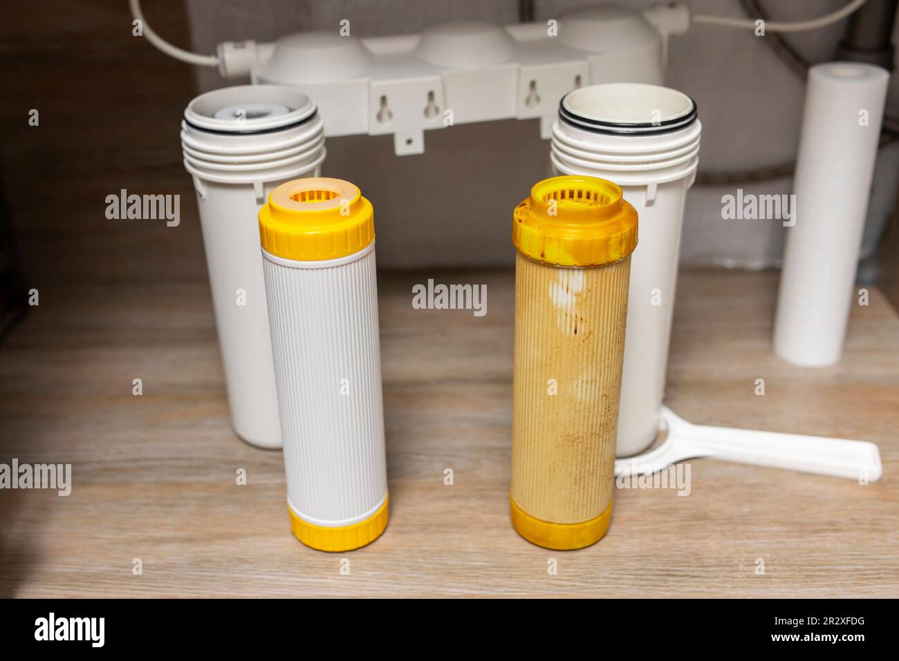 Installazione di filtri di purificazione dell'acqua sotto il lavello della cucina nell'armadio Foto Stock
