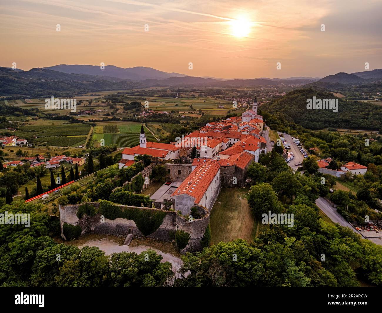 Vipaski Krizh - una bella cittadina su una collina nella valle di Vipava, Slovenia. Vista aerea con paesaggio rurale al tramonto Foto Stock