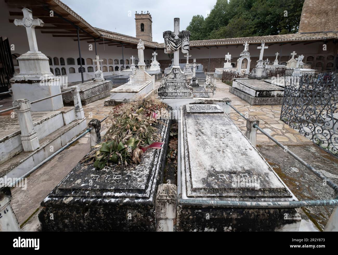 Antiche tombe con fiori secchi e corone nel cimitero di Brihuega, all'interno del castello di Peña Bermeja Foto Stock