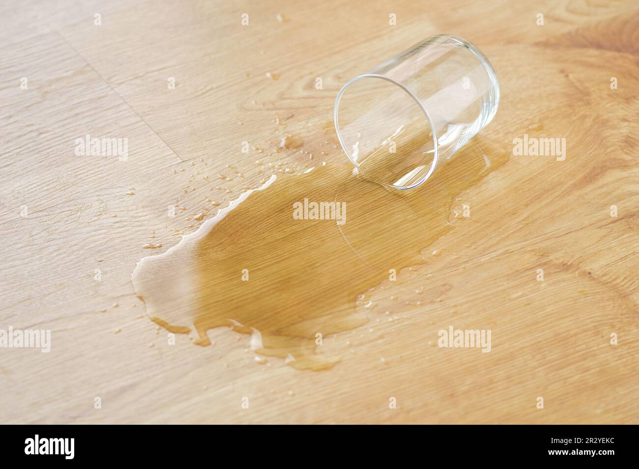 parquet in legno laminato con un bicchiere d'acqua sulla superficie Foto Stock
