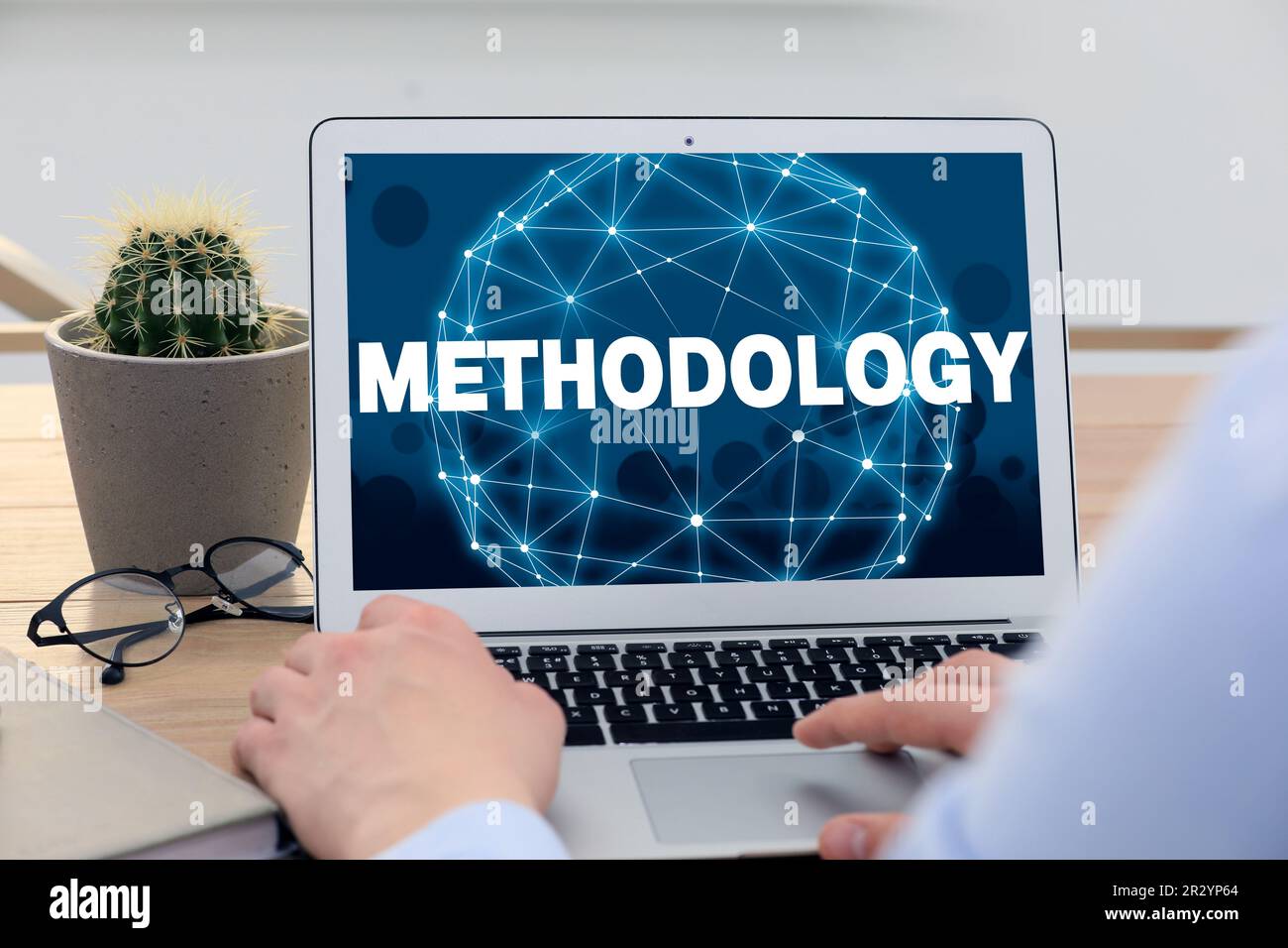Concetto di metodologia. Uomo che usa un notebook moderno al tavolo al chiuso, in primo piano Foto Stock