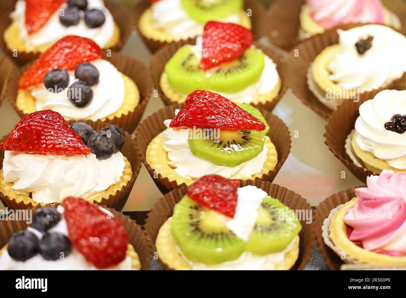 Torte con frutta fresca e frutti di bosco, focus selettivo. Dolce con fragole, kiwi e mirtilli Foto Stock