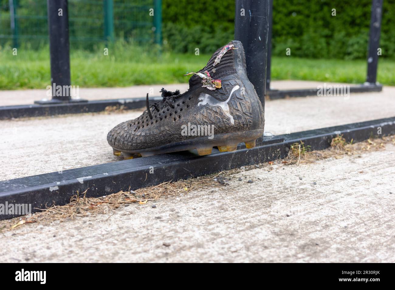 Scarpa da calcio Puma singola lasciata al campo di allenamento Foto Stock