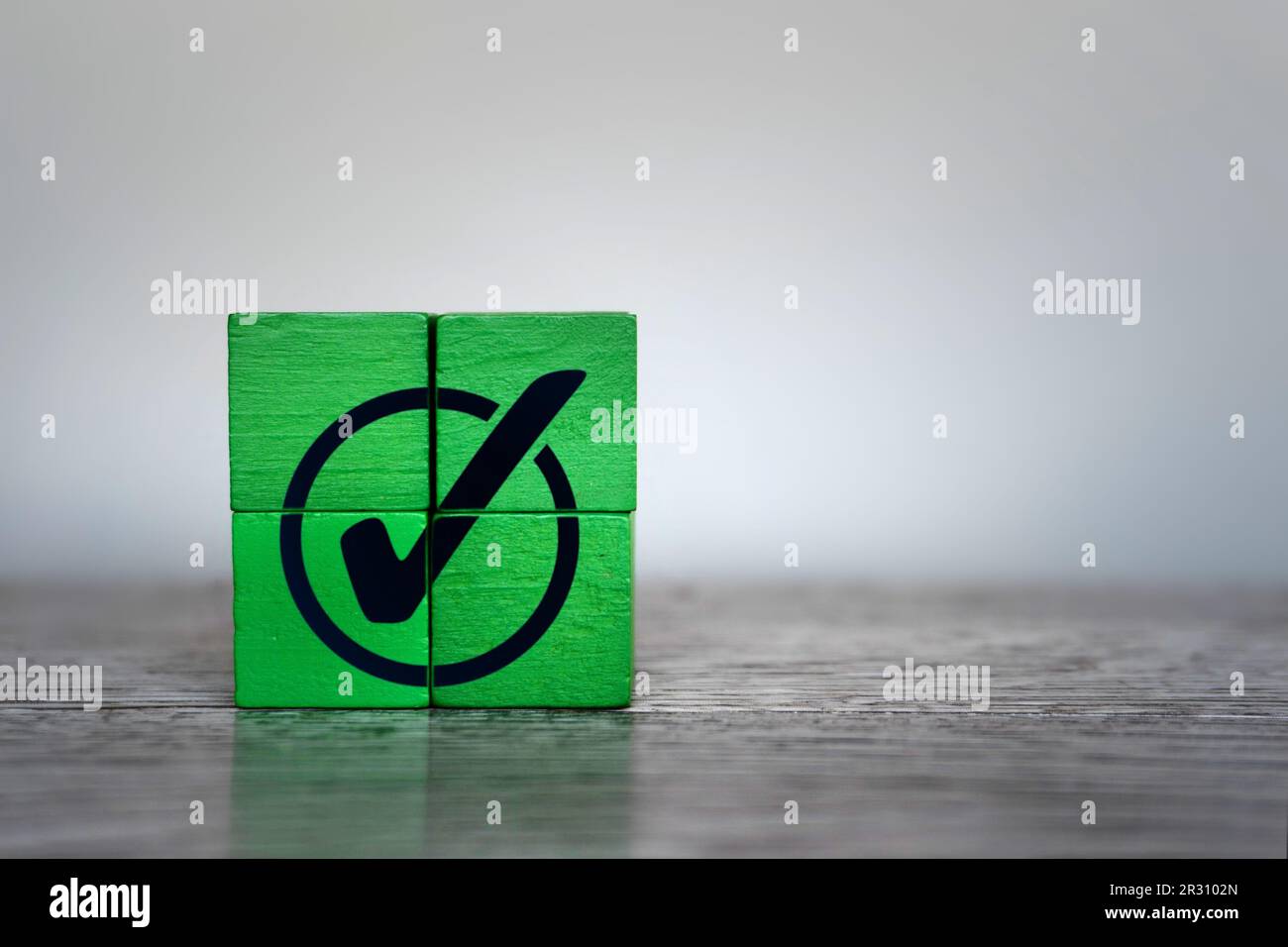 Cubi di legno verde con icona di segno di spunta. Conformità alle normative aziendali, risultati, attività completata Foto Stock