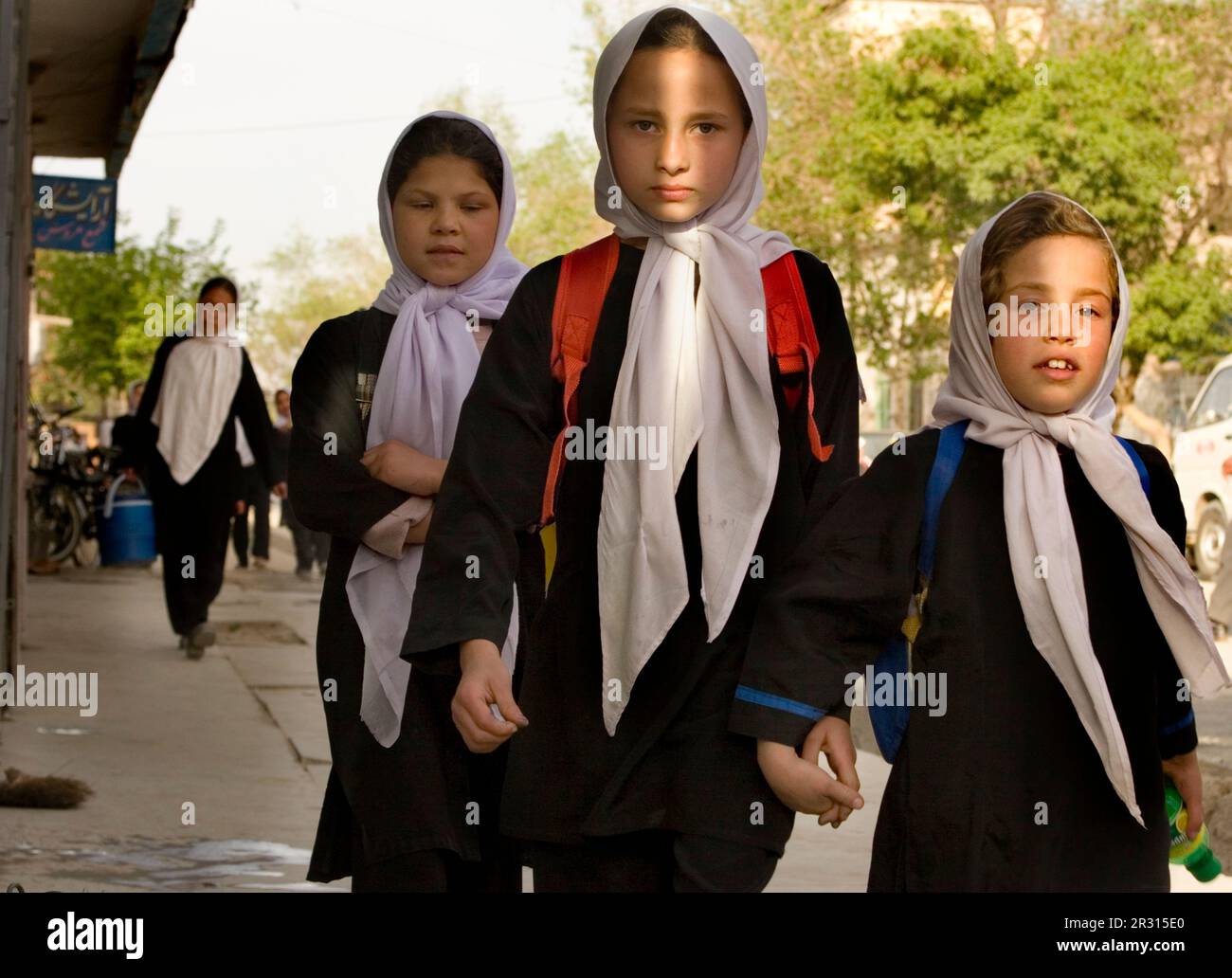 Le ragazze in sciarpe bianche della testa fanno il loro senso a casa dalla scuola dopo la classe a Kabul. Foto Stock