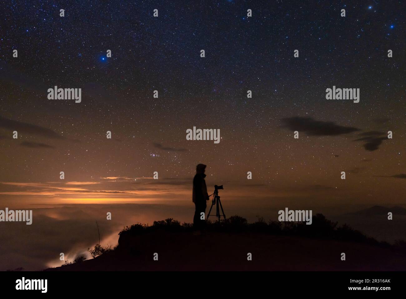 Uomo che fotografa il cielo stellato dopo il tramonto Foto Stock