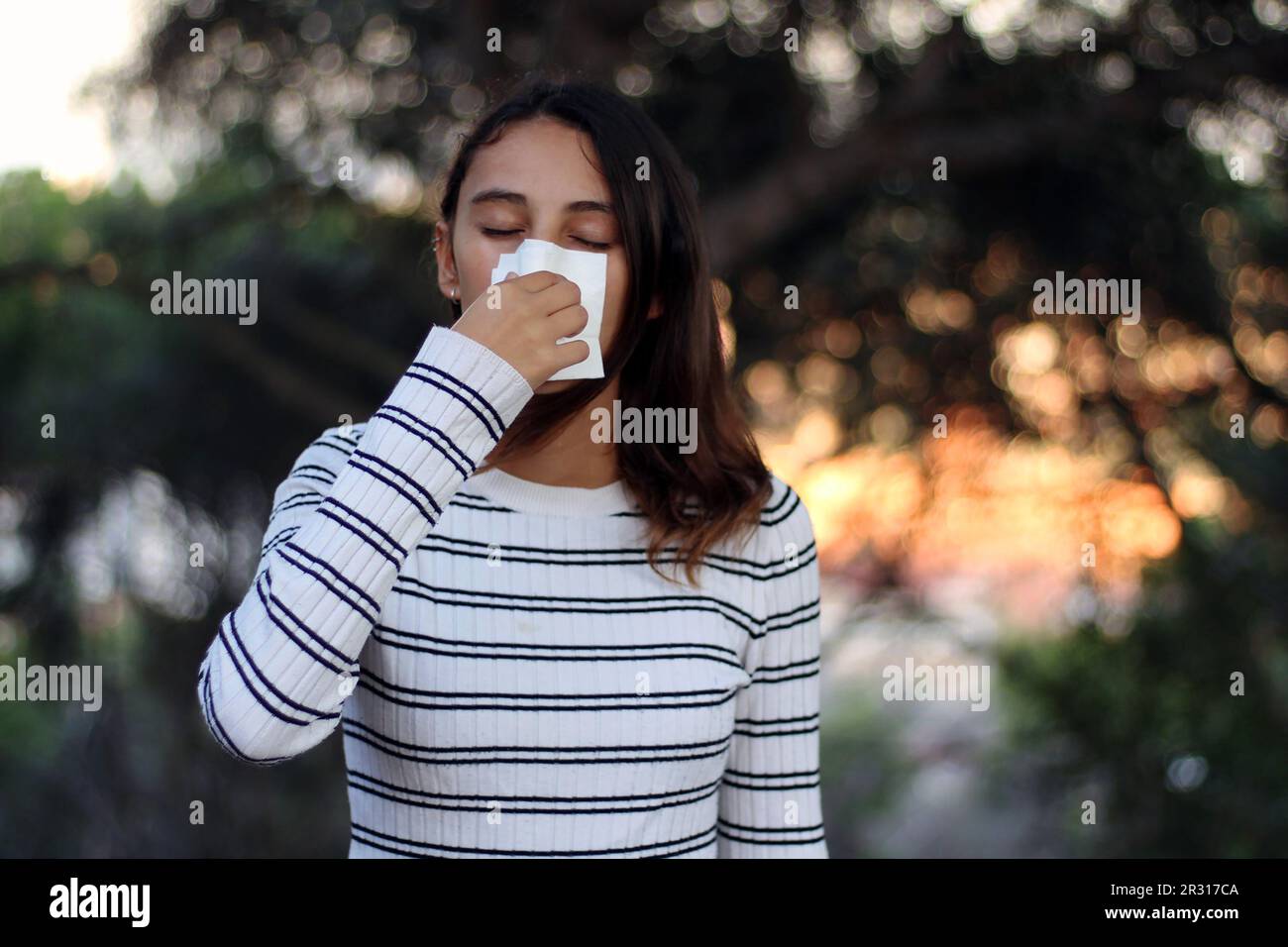 Concetto di salute e medicina - giovane donna che soffia il naso nel tessuto. Foto Stock