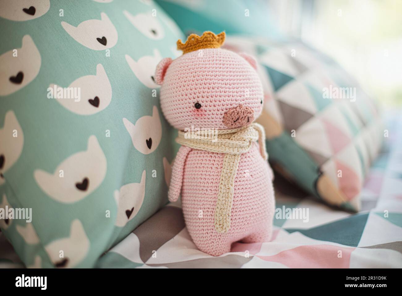 Primo piano di un maiale a crochet fatto in casa (Amigurumi) su un letto Foto Stock
