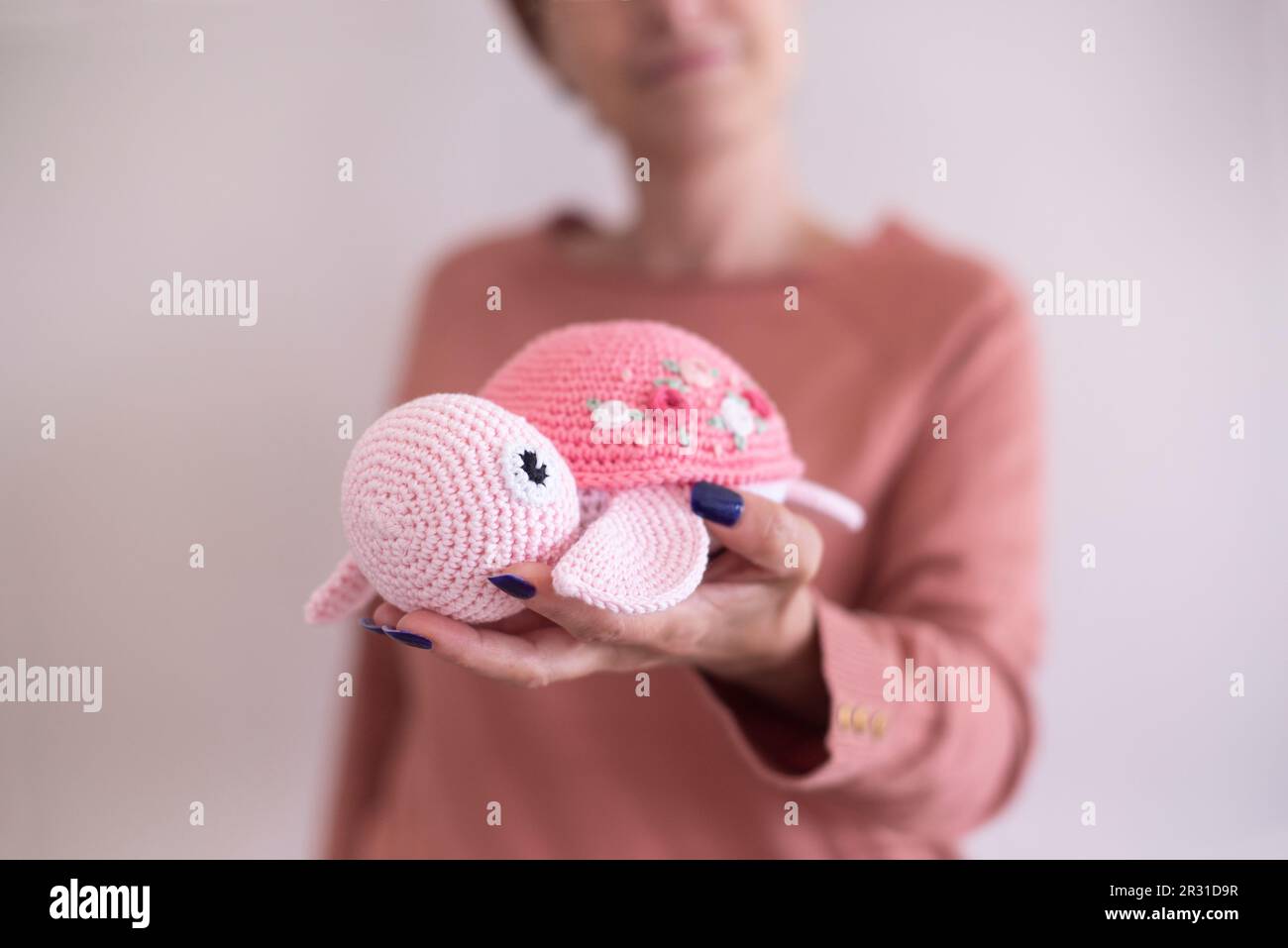 Donna con una tartaruga a crochet fatta in casa (Amigurumi) Foto Stock