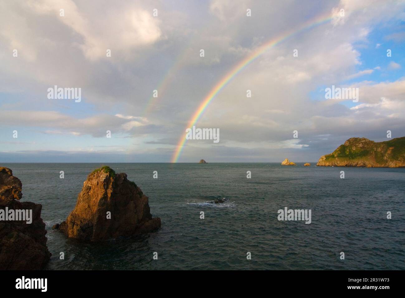 Vista sulla costa con arcobaleno Foto Stock