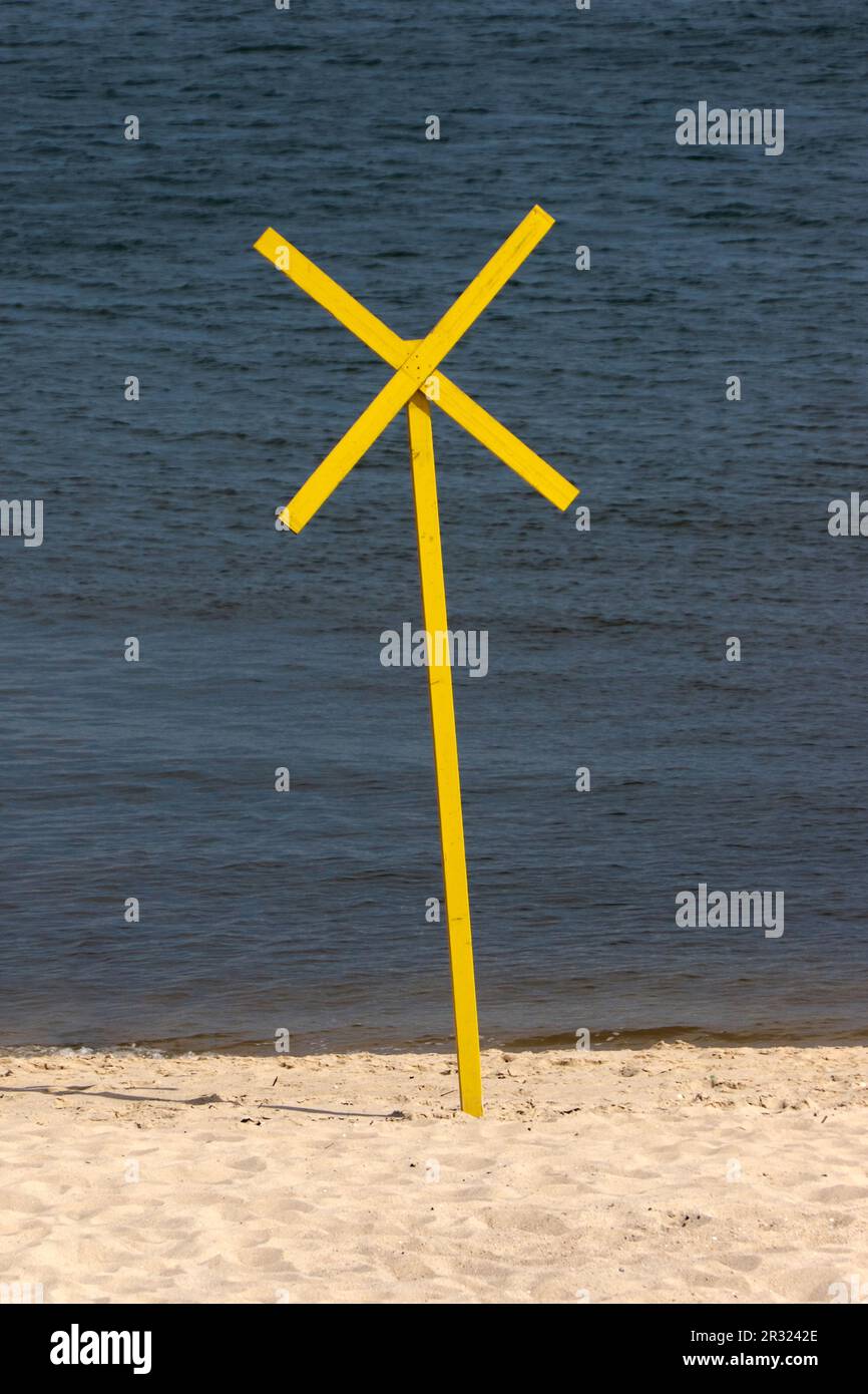 Spiaggia con croce gialla di avvertimento Foto Stock