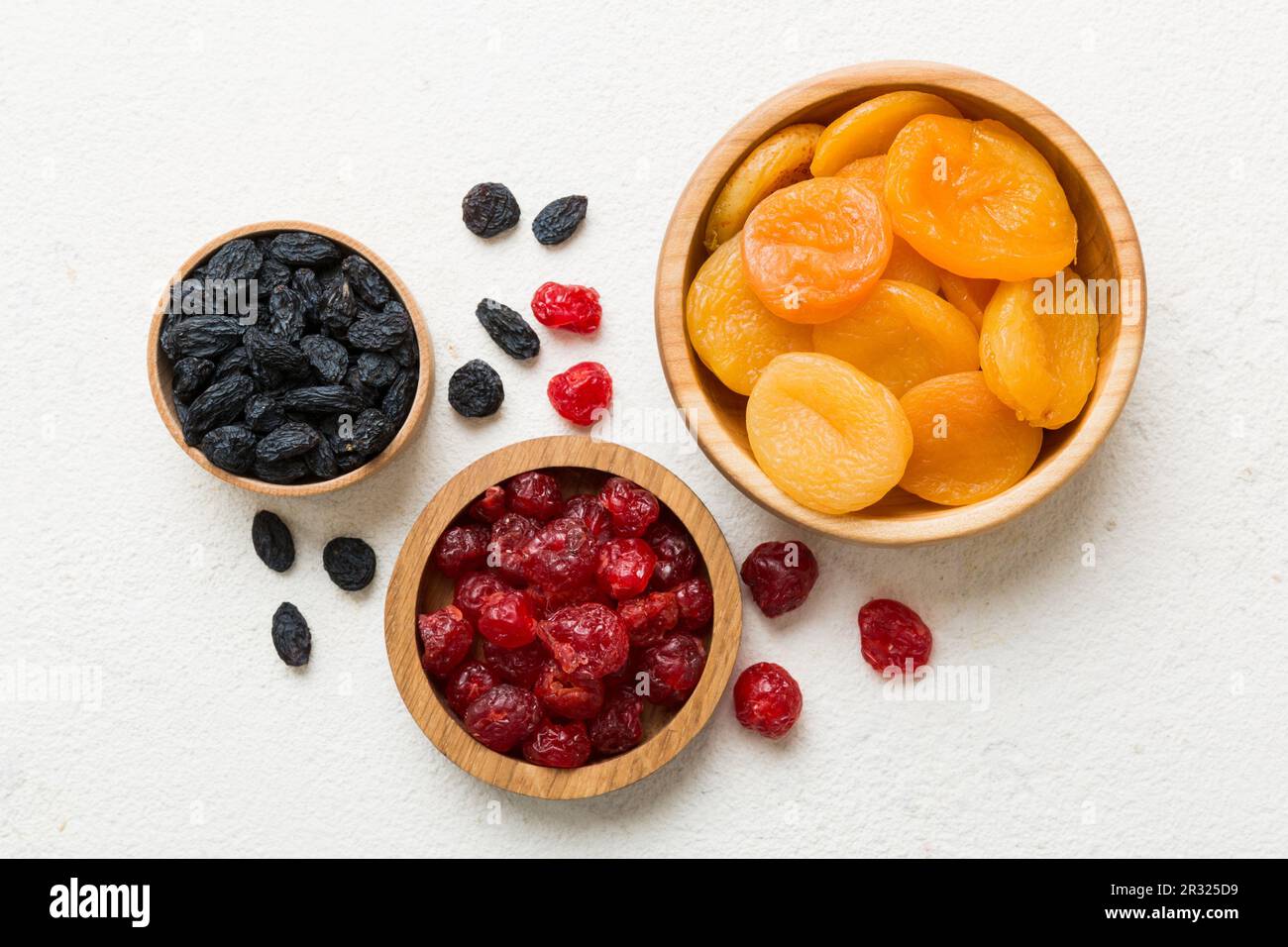 Ciotola con diversi frutti secchi sullo sfondo del tavolo, vista dall'alto. Stile di vita sano con spazio copia. Foto Stock