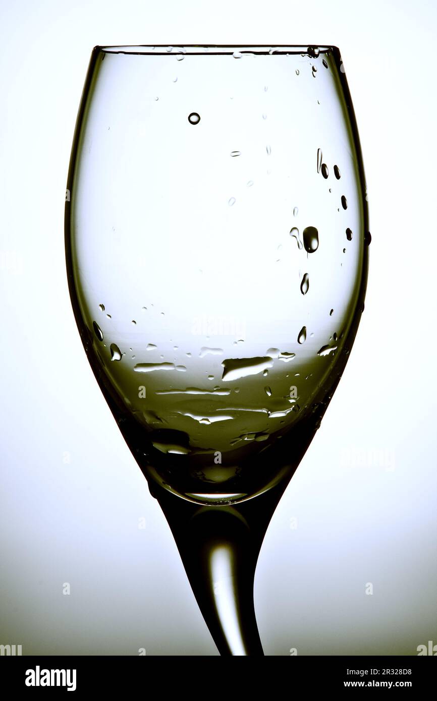 Bicchiere da vino curvo con gocce Foto Stock