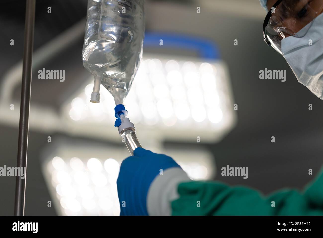 Chirurgo asiatico maschio che ispeziona il gocciolamento in sala operatoria in ospedale Foto Stock