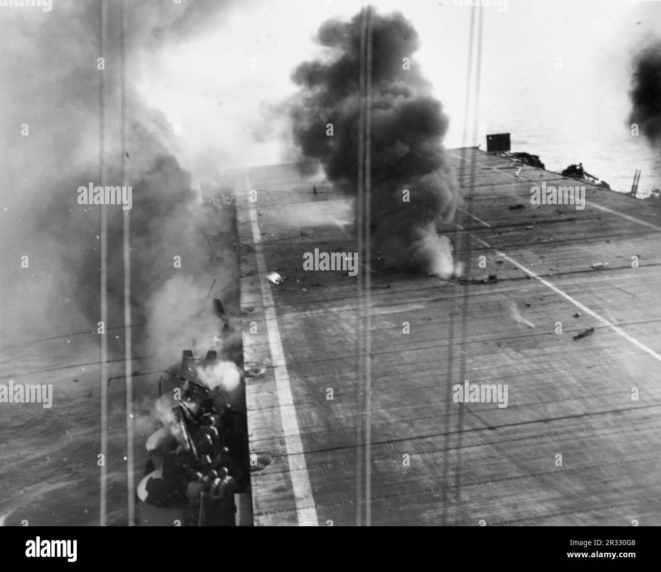 Vista dell'attacco di un aereo suicida giapponese A6M5 kamikaze a bordo degli Stati Uniti Portatore di scorta della Marina USS Suwannee (CVE-27) al largo delle Filippine il 25 ottobre 1944: La bomba da 250 kg del kamikaze è appena esplosa tra i ponti di volo e di hangar e si è spento il fuoco. Quando il Giappone stava affrontando la sconfitta alla fine del 1944 ha scelto di distruggere le navi statunitensi con attentati suicidi, noti come Kamikaze.questi attacchi erano una potente arma fisica e psicologica e affondarono un totale di 47 navi al costo di oltre 3000 piloti e aerei. Alla fine del 1944 la Marina americana era abbastanza grande da rendere le perdite insignificanti e loro Foto Stock